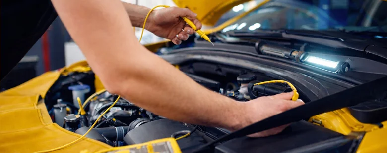 Professional auto electrical repair diagnostics in California – mechanic testing wiring and systems on yellow car at Azimov Collision