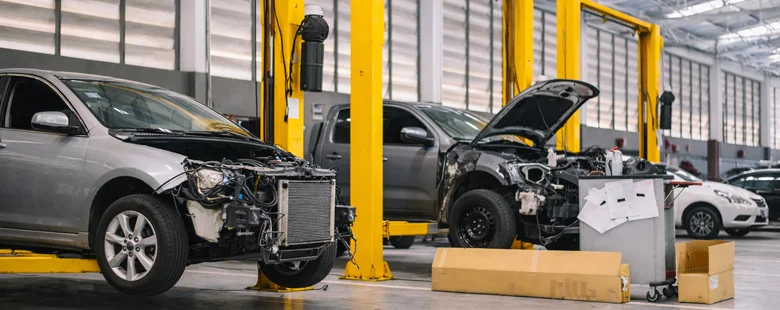 Severe collision damage on car undergoing professional repair at Azimov Collision workshop in California