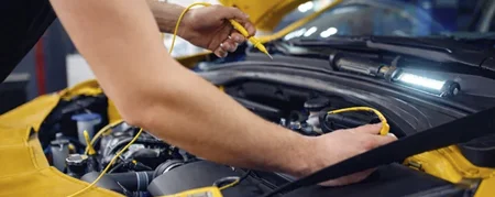 Professional auto electrical repair diagnostics in California – mechanic testing wiring and systems on yellow car at Azimov Collision